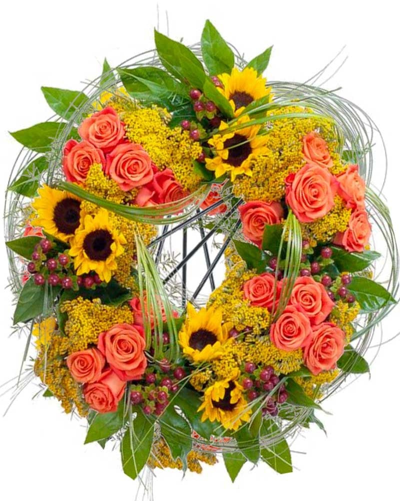 Corona de flores funeraria con girasoles y rosas.